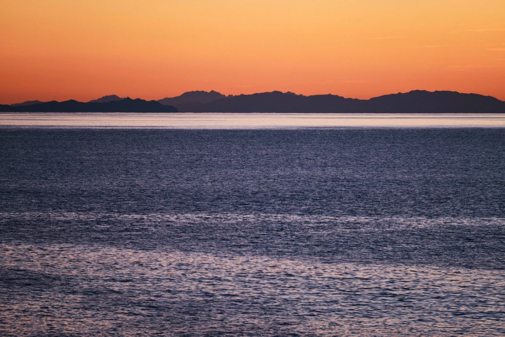 Orange sky at sunset over the Tyrrhenian Sea with the island of Elba on the horizon in Tuscany
