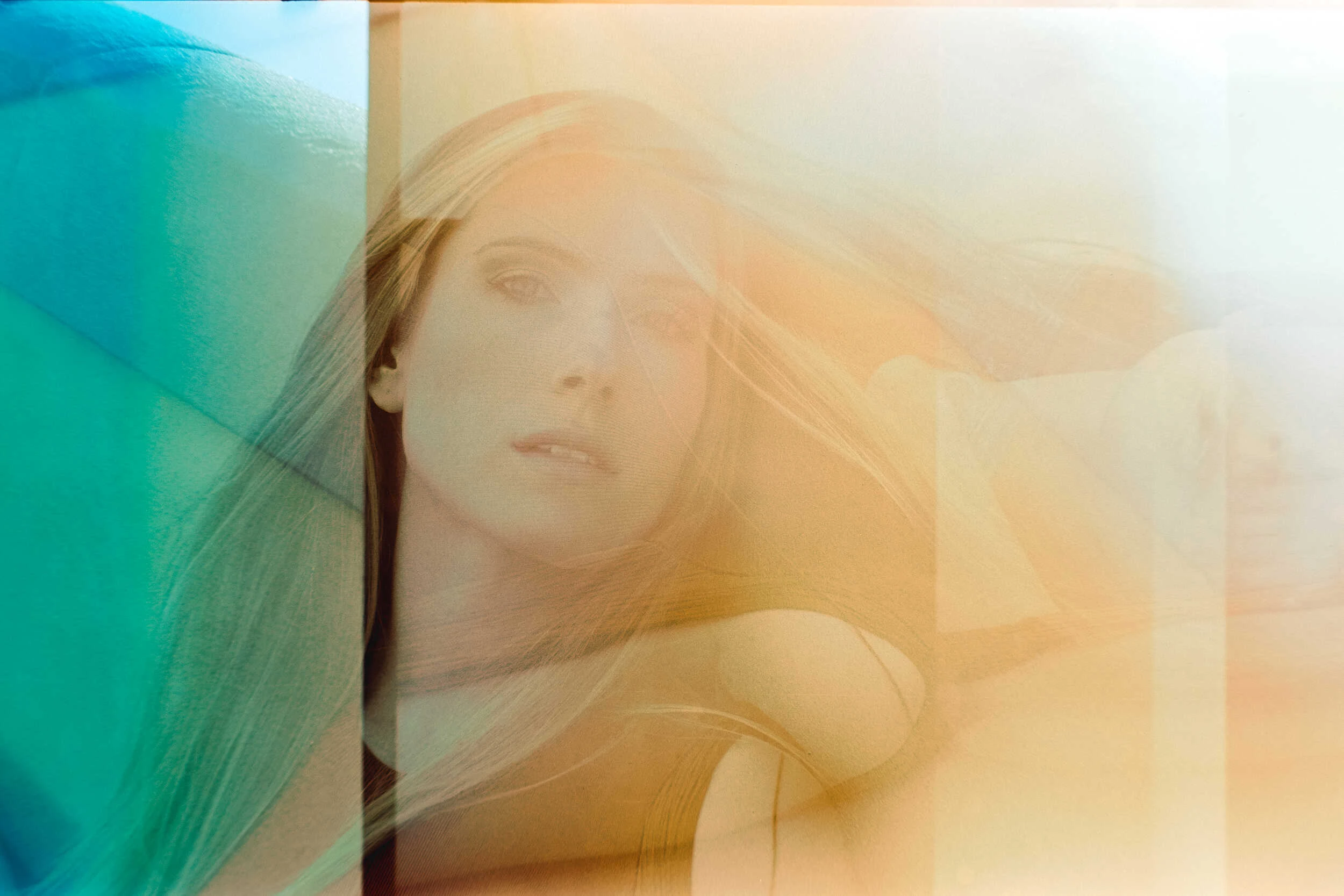 Blonde model behind a colourful glass reflection in Florence, hybrid analog and iPhone photography