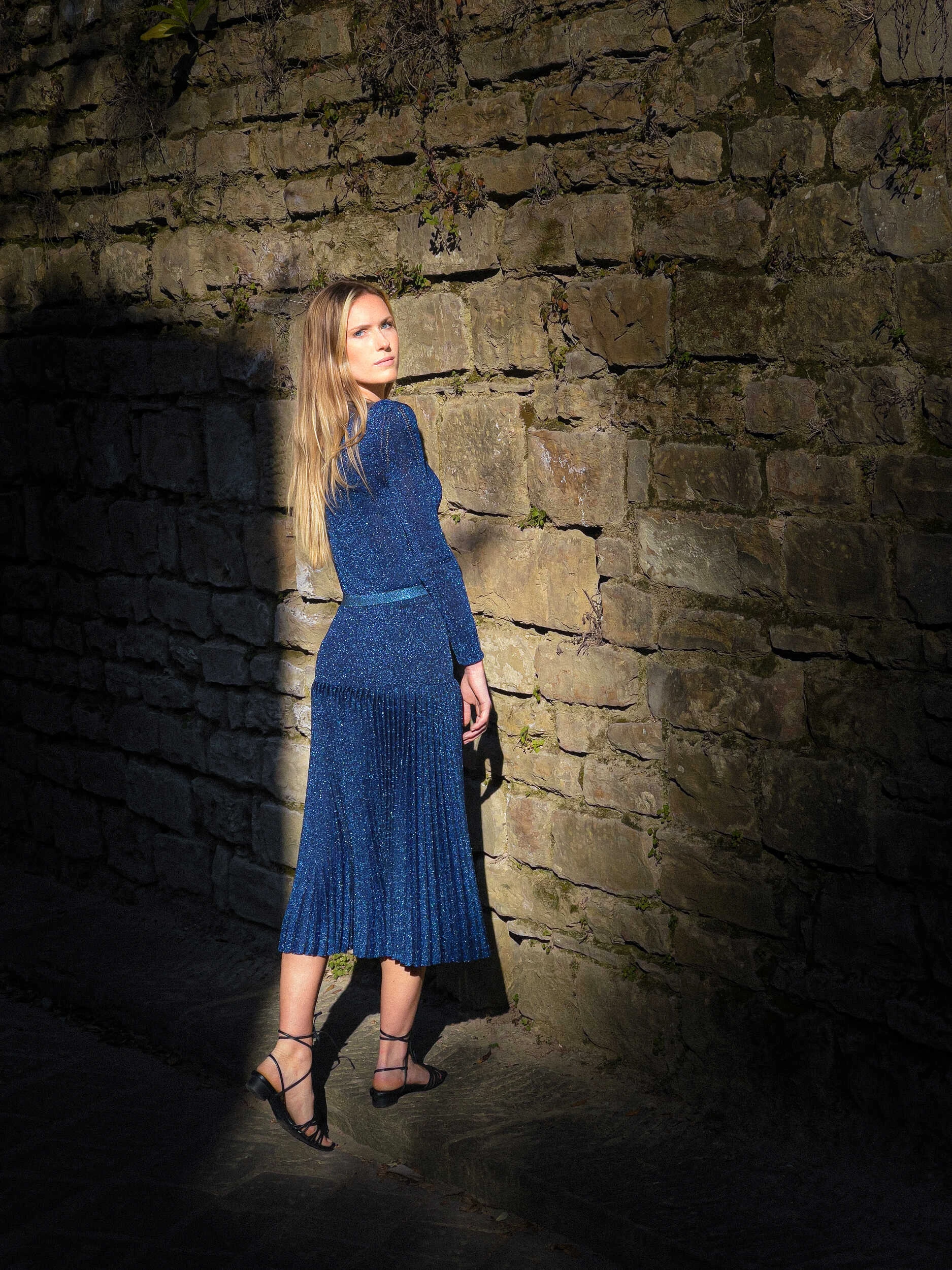 Blonde model in a navy knit dress in a stone alley in Florence, hybrid photography