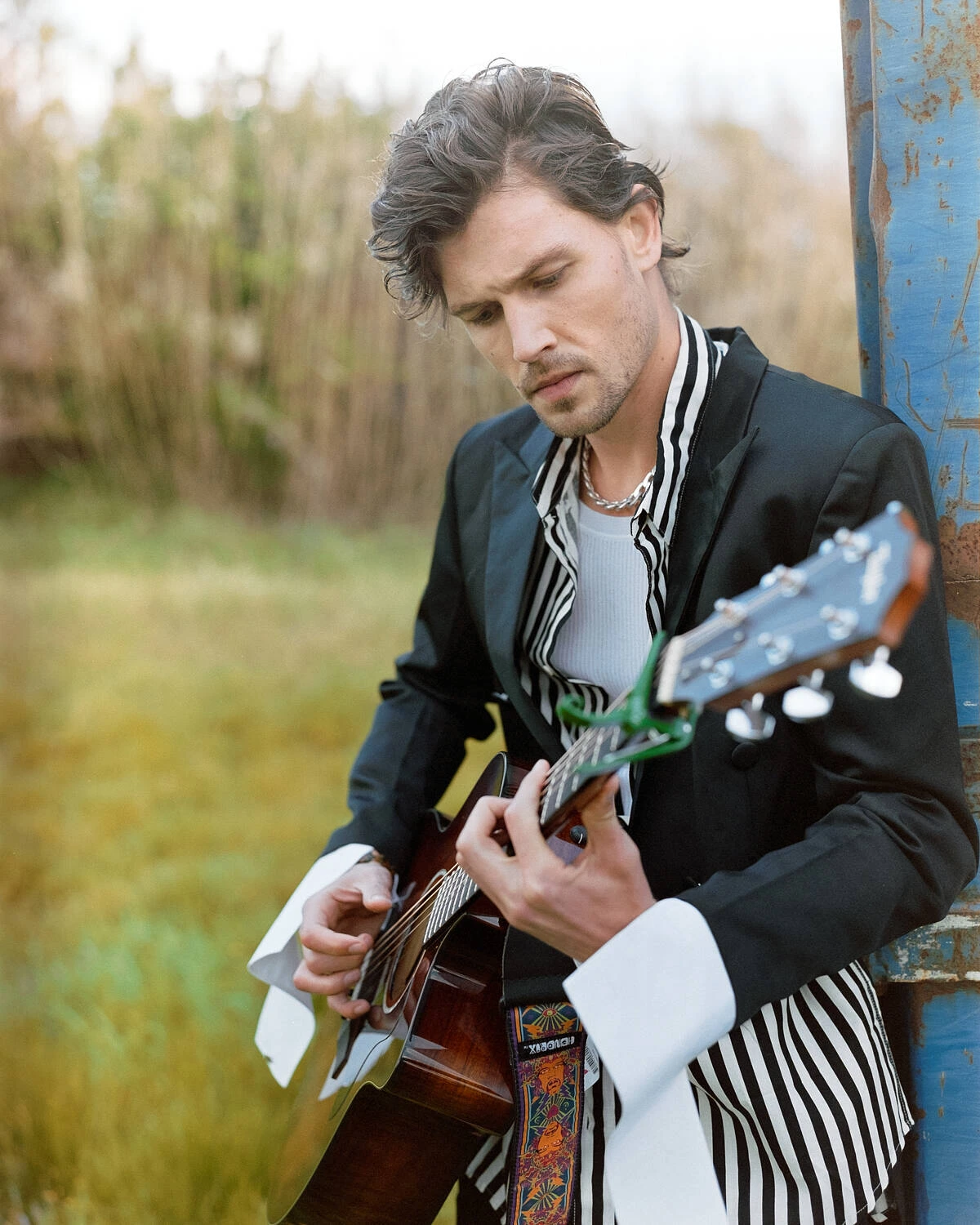 Robbie playing guitar in a field, shot on Fujifilm Pro 400H film