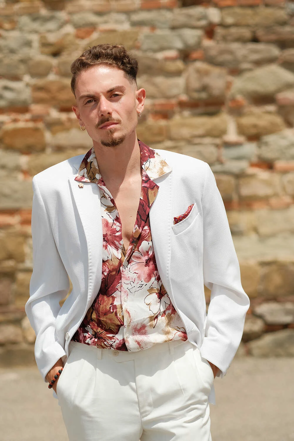 Man in a white suit over a floral shirt, street style at Pitti Uomo 100 in Florence