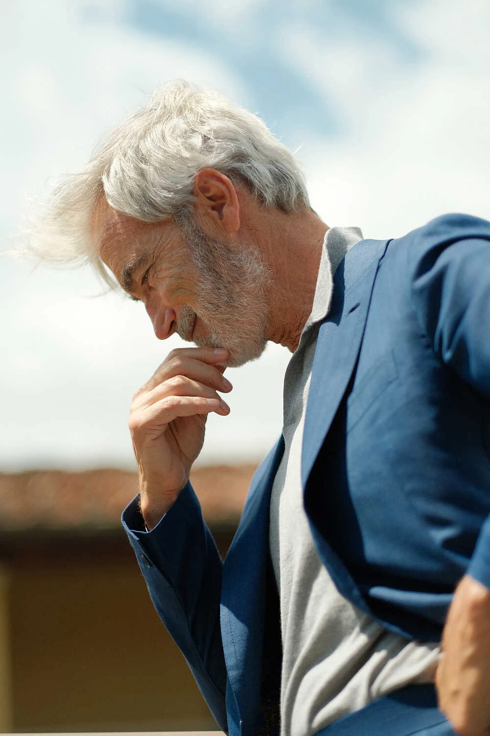 Man in a navy suit over a grey top, street style at Pitti Uomo 100 in Florence