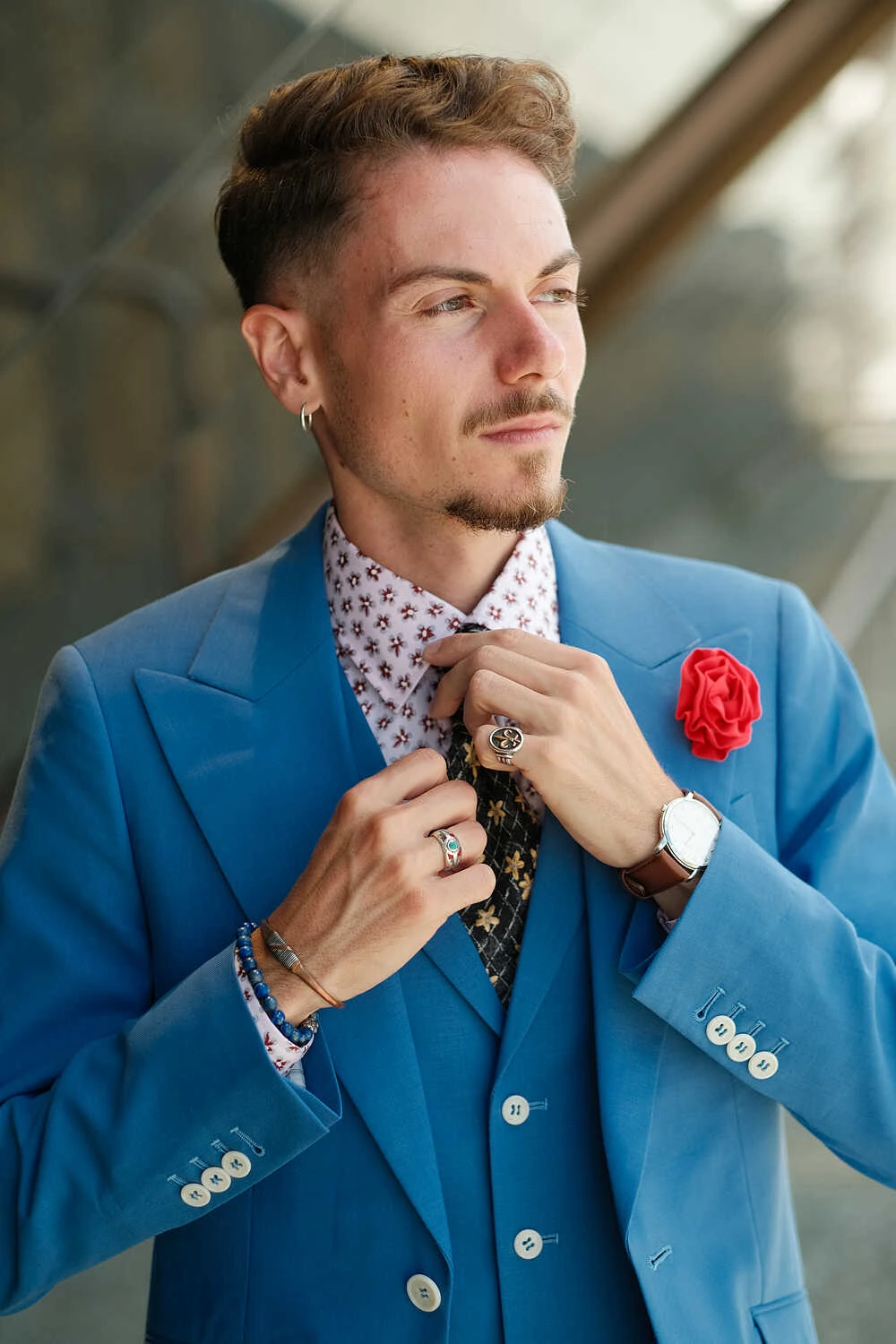 Model adjusting his tie in a blue suit for Hockerty in Florence