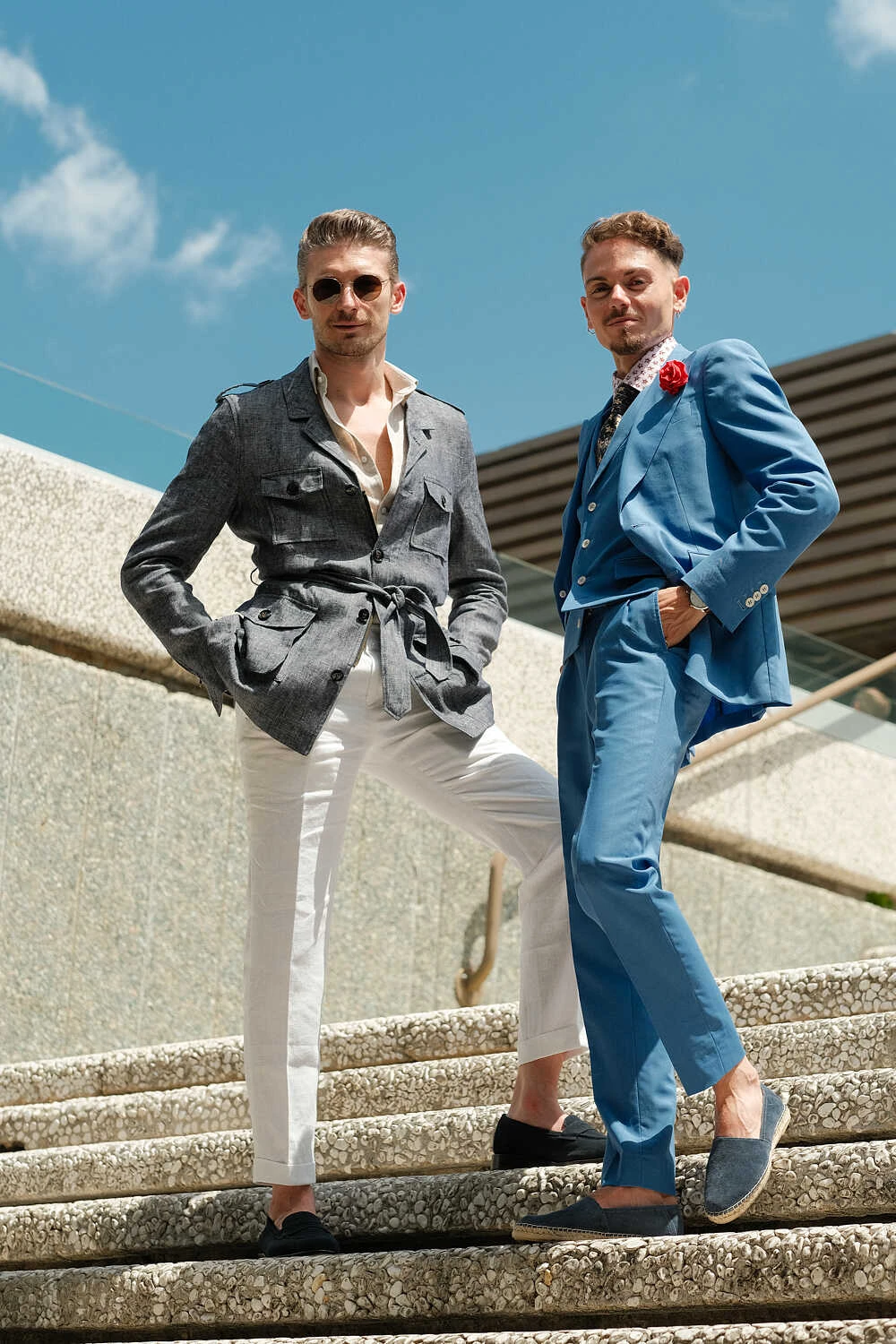 Two models in a grey jacket and blue suit descending stairs for Hockerty in Florence