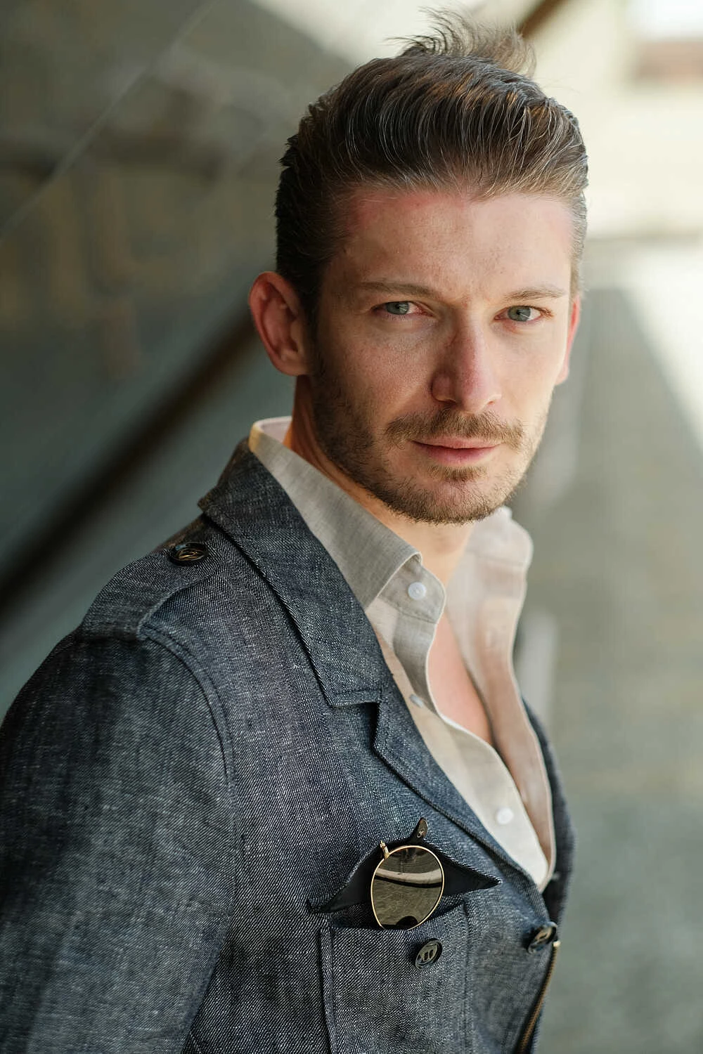 Close-up portrait of a model in a grey jacket for Hockerty at Pitti Uomo 100