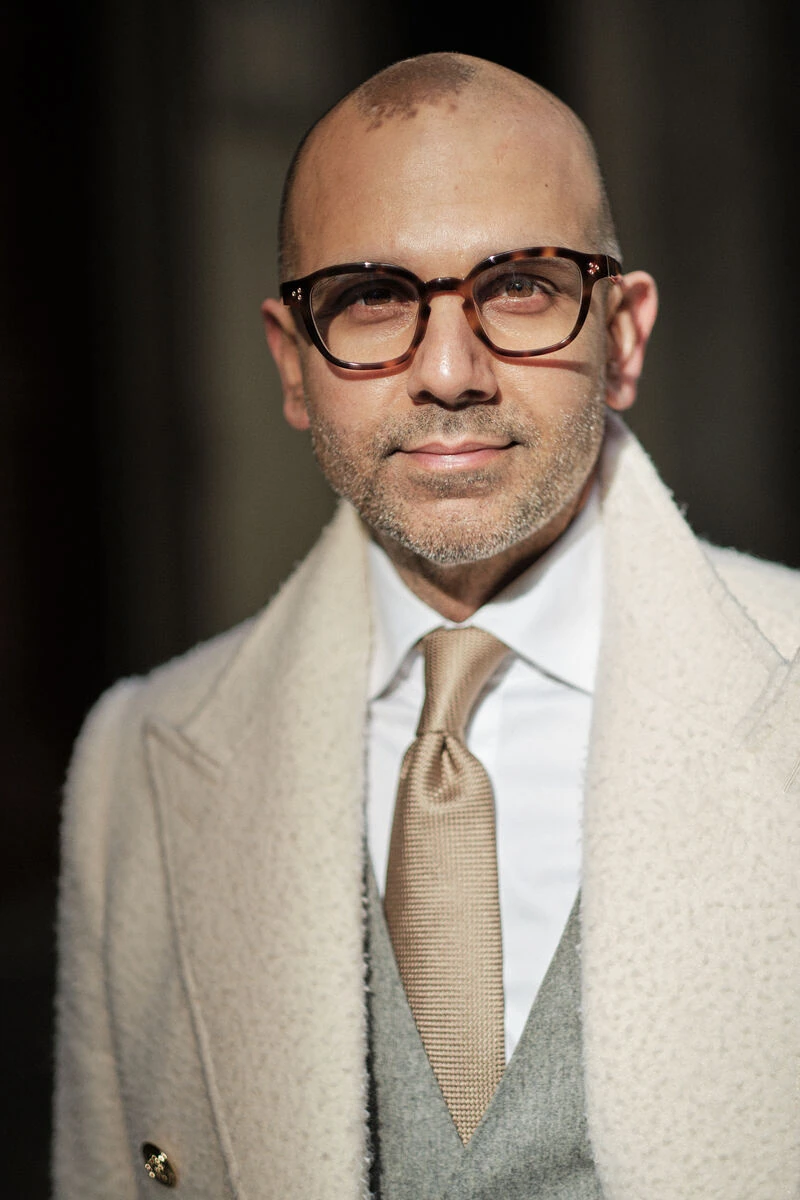 Close-up portrait of a man in a cream coat and tan tie, male fashion street style in Florence