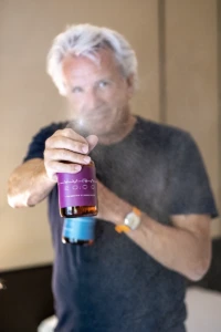 Man holding a purple YVRA perfume bottle in Amsterdam