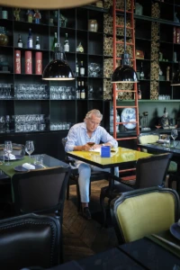 Man seated at a table in the Conservatorium Hotel restaurant in Amsterdam, YVRA perfume shoot