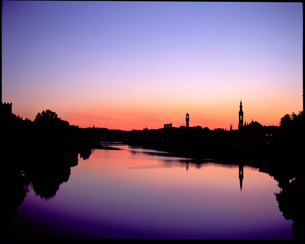 Film photograph of a colourful sunset over the Arno and the Florence skyline