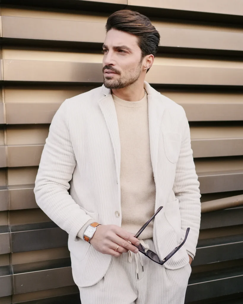 Man in a cream knitted suit and beige turtleneck, street style at Pitti Uomo 105 in Florence