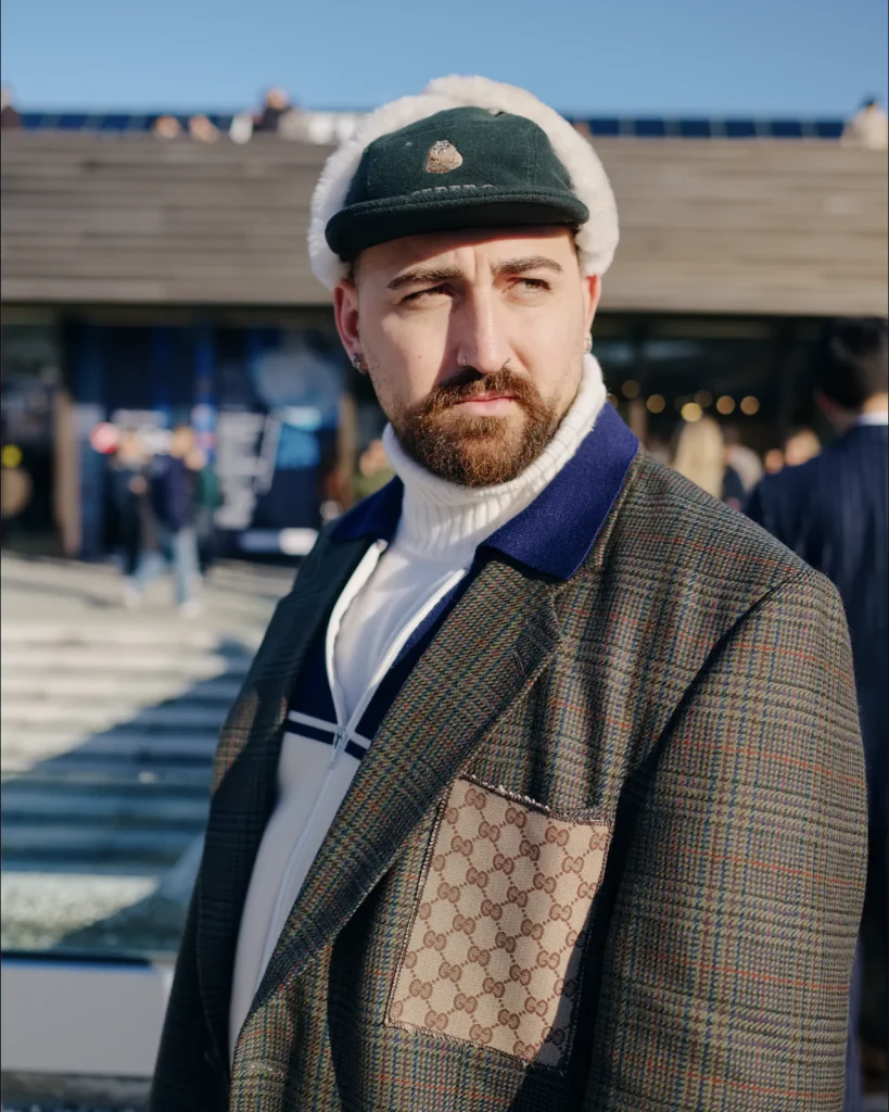 Bearded man in a checked tweed jacket and green corduroy cap, street style at Pitti Uomo 105 in Florence