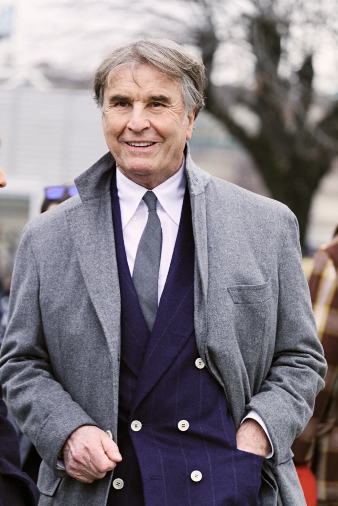 Mr.Brunello Cucinelli in a grey overcoat with a navy pinstriped waistcoat and grey tie at the Pitti Immagine Uomo 109 fair, Florence