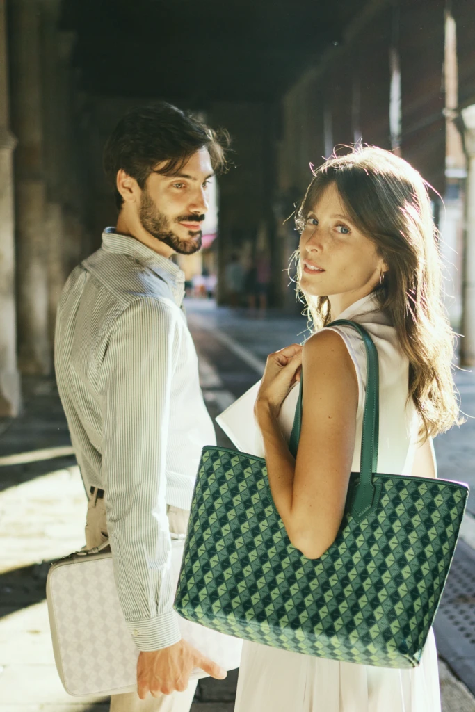 Couple beneath Venice arches carrying a Vonto green woven tote and a Vonto white leather briefcase