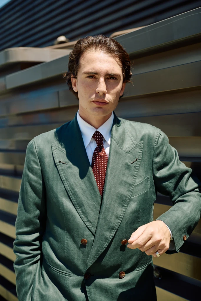 Man in a dark green double-breasted jacket with a polka dot tie at Pitti Immagine Uomo 110