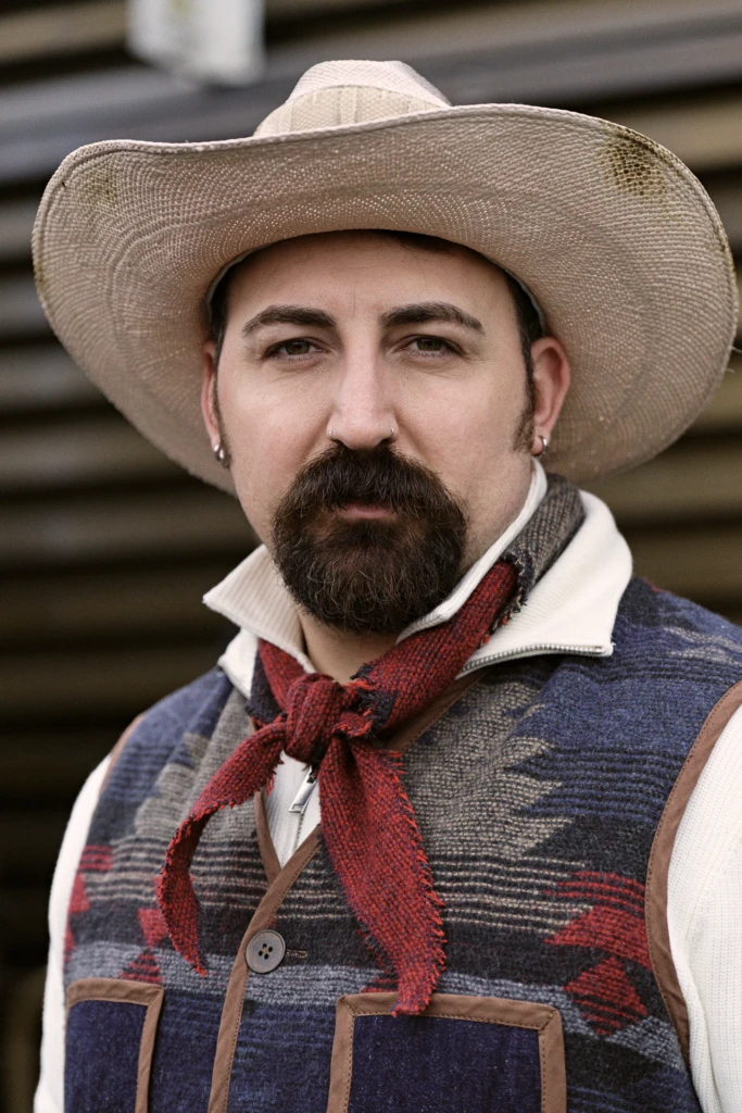 Man in a straw cowboy hat and red bandana neckerchief with a patchwork wool vest, Pitti Immagine Uomo 109 fair, Florence