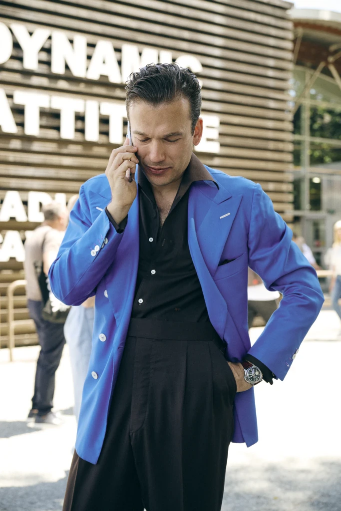 Man in a blue blazer and black shirt talking on the phone