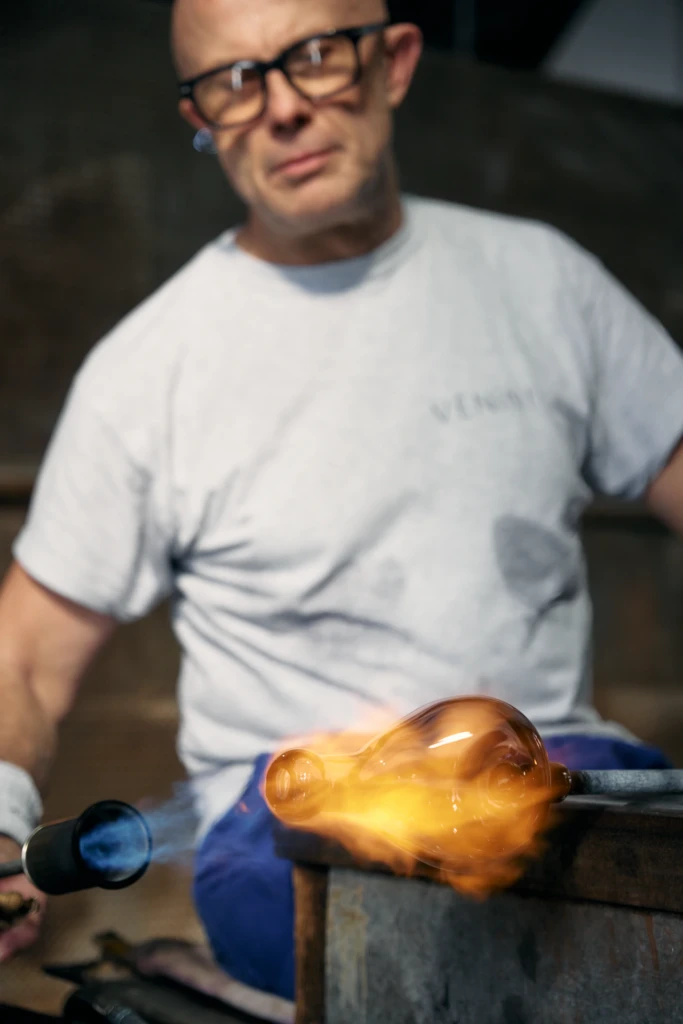 Molten glass glowing on a blowpipe, Venini foundry Murano
