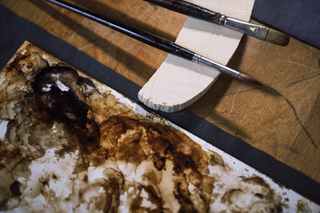 Detail of aged violin varnish being restored, Florence luthier studio