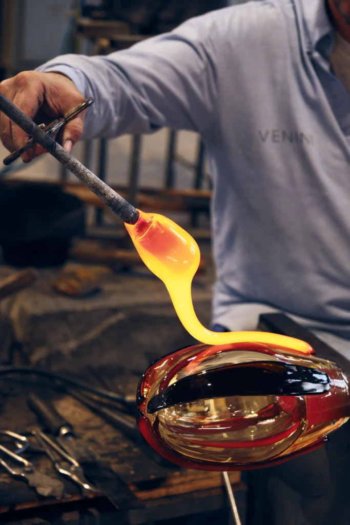 Glassblower rotating a piece over the flame, Venini Murano