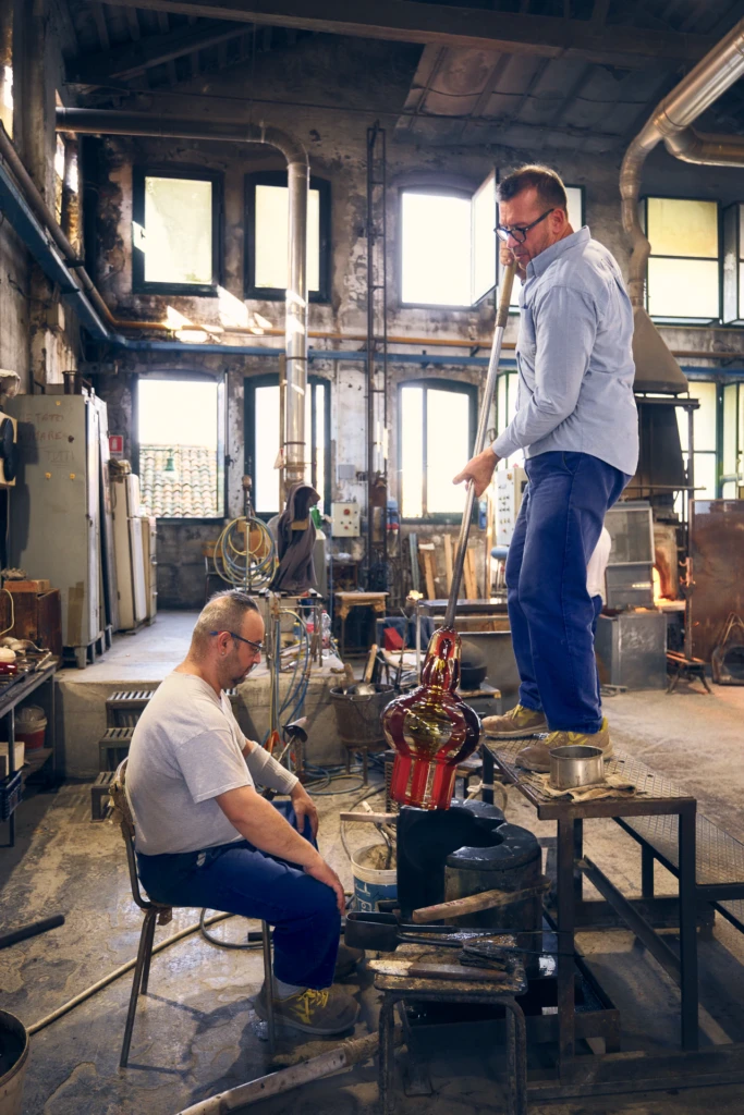 Craftsman finishing a Venini glass vessel, Murano Venice