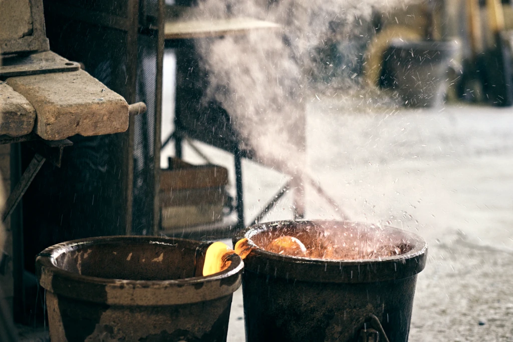 Sparks and steam rising from crucibles of molten glass at the Murano glass foundry