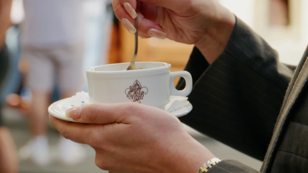 Close-up of hands stirring espresso in a Rivoire-branded cup at a Florence café
