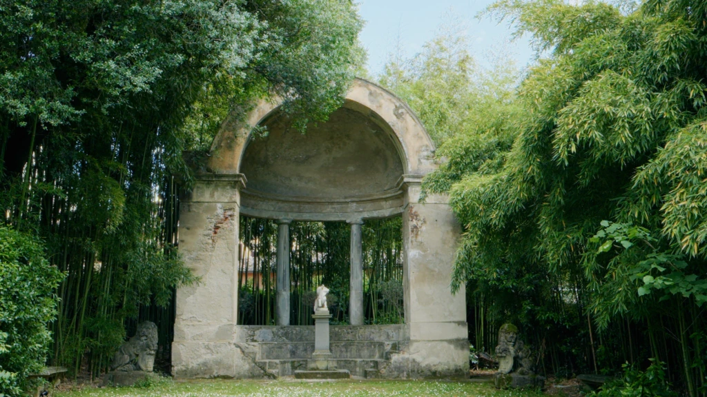 A crumbling stone garden pavilion framed by bamboo in a hidden Florence villa garden
